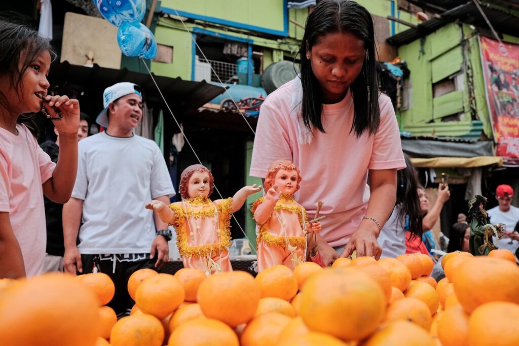 santo nino statuette displayed on a fruit cart in tondo, manila, philippines.